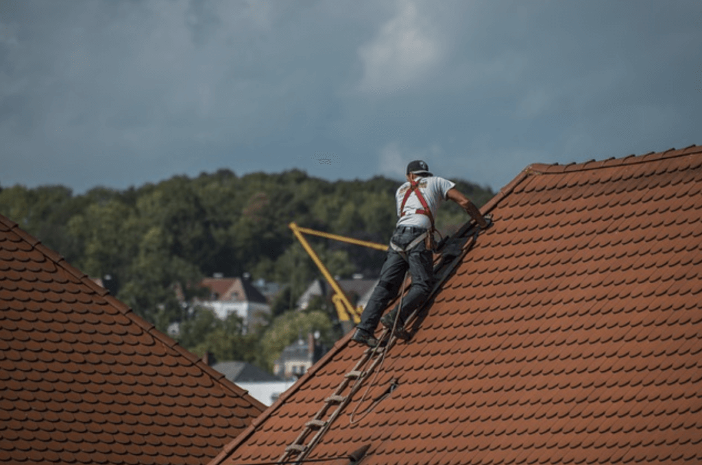 A roofer working to maintain a tile roof