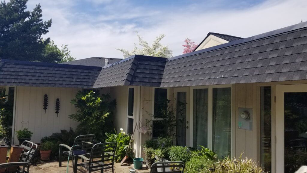 Composition shingles installed over the sloped portions of a roof in Salem, Oregon.
